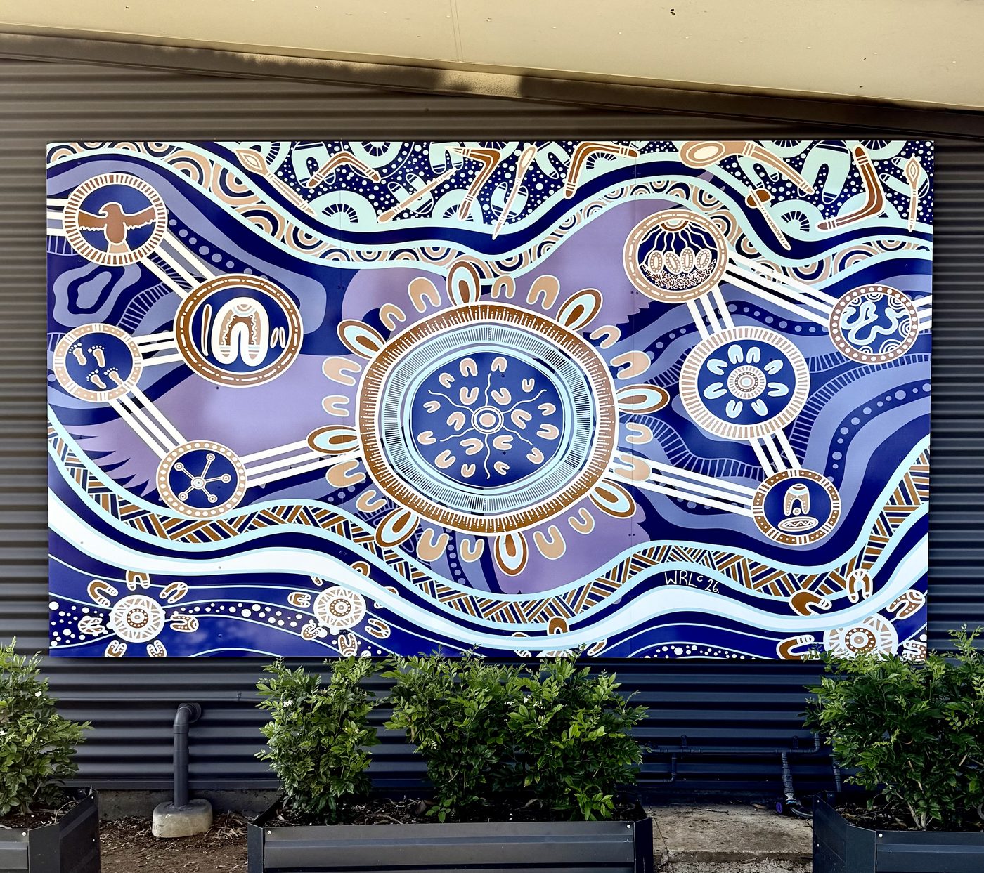 Large printed mural panel of Aboriginal artwork mounted on a building